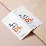 Free Bifold Dl Flyer Mockup Lying on a Wooden Board PSD