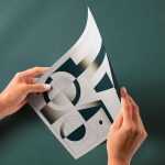 Free Hand Holding Glossy Paper Mockup PSD