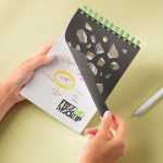 Free Hands Holding Spiral Spiral Notepad Mockup PSD
