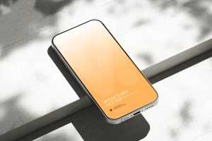 Free iPhone 16 Pro Mockup on Bright Concrete Surface with Shadows