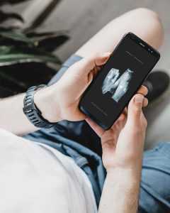 Free Man Watching his Android Phone Mockup PSD