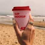 Free Paper Coffee Cup on the Beach Mockup