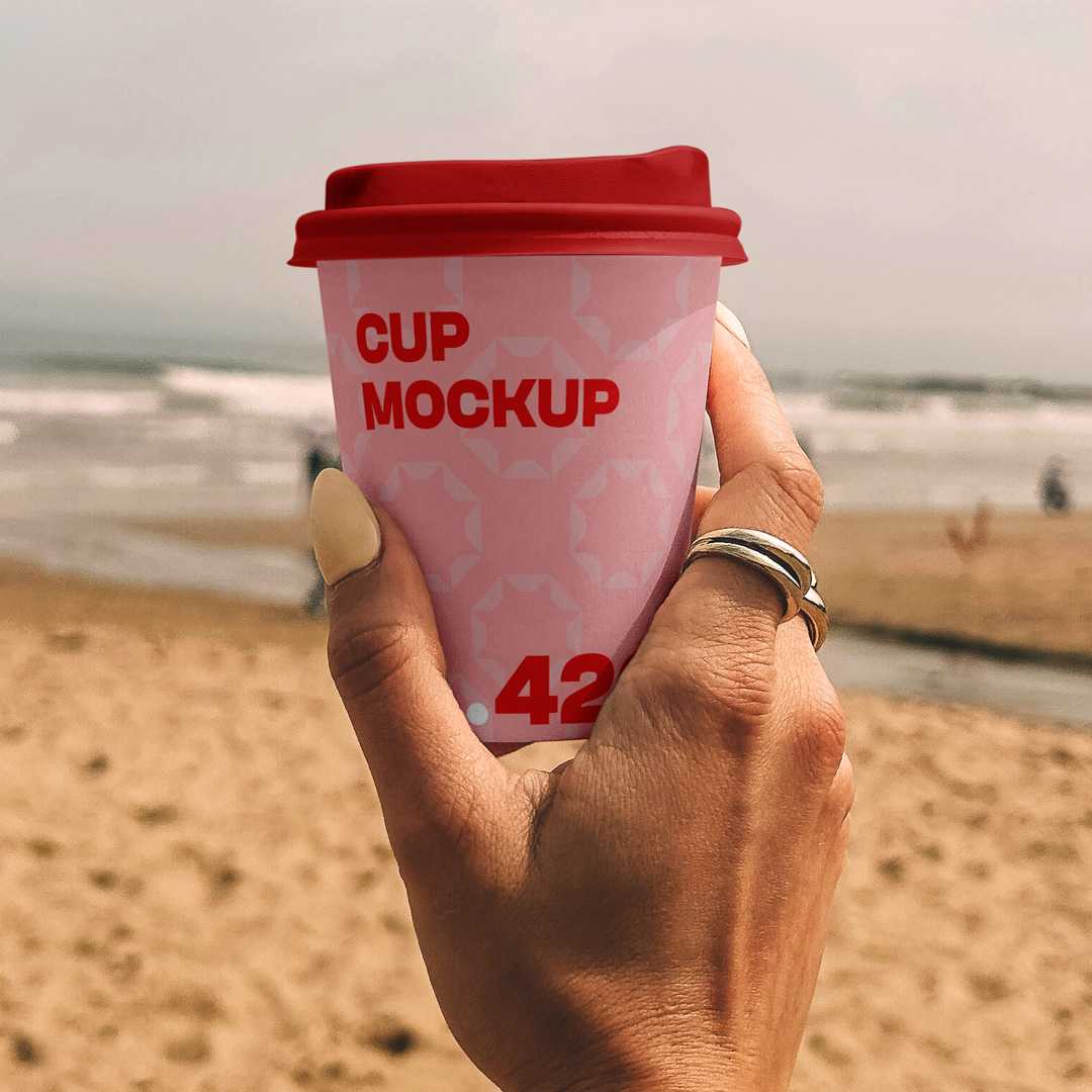 Free Paper Coffee Cup on the Beach Mockup
