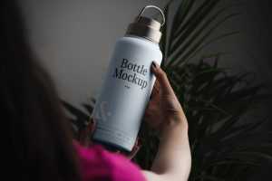 Free Woman Holding Bottle Mockup