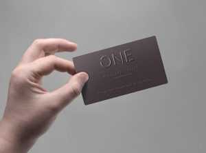 Hand Holding Logo Embossed Business Card Mockup Free PSD