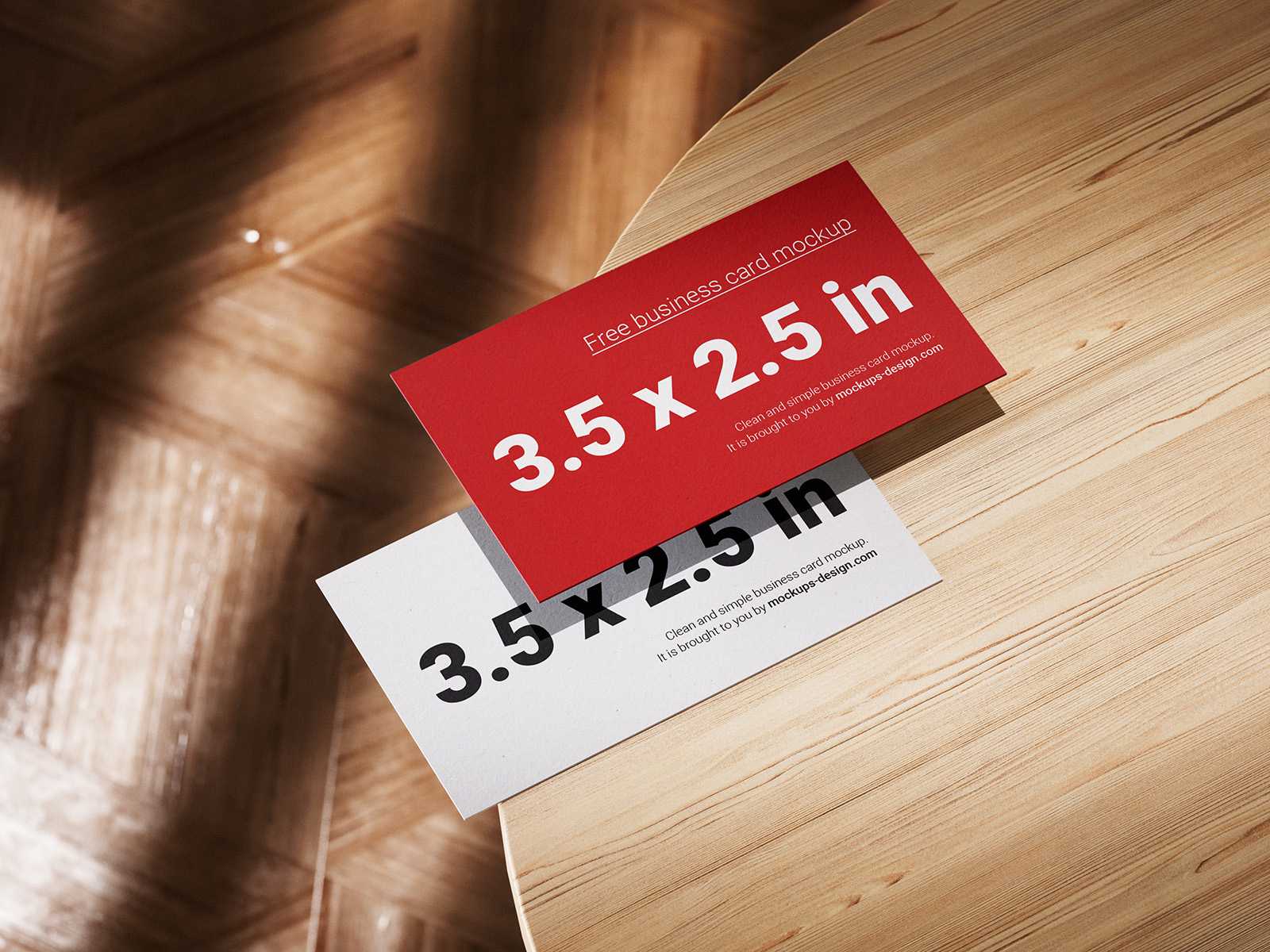 Business cards lying on a wooden table mockup