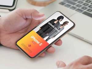Free Person Holding Phone Mockup (PSD)